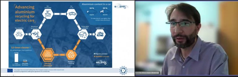 Screenshot from an online webinar, showing a man wearing glasses next to a presentation slide including text, logo, icons, coloured background and shapes.