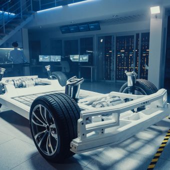 Concept of Authentic Electric Car Platform Chassis Prototype Standing in High Tech Industrial Machinery Design Laboratory. Hybrid Frame include Tires, Suspension, Engine and Battery.
